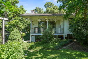 View of front of property with a chimney and a porch
