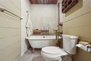 Bathroom featuring a freestanding bath, toilet, and wooden ceiling