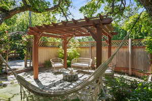 Fenced backyard featuring a patio, a pergola, and a fire pit