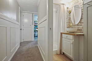 Hall with a sink and light carpet