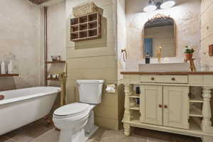 Bathroom with a soaking tub, vanity, toilet, and tile patterned floors