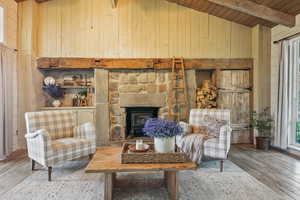 Living area featuring wooden walls, wood ceiling with exposed beams, hardwood / wood-style floors, and high vaulted ceiling