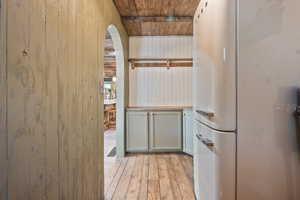 Interior space featuring wood walls, arched walkways, wood ceiling, and light wood-type flooring