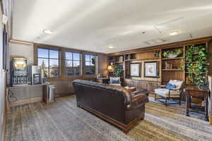 Living room with carpet floors, built in features, attic access, and baseboards