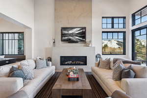Living room featuring a towering ceiling and a glass covered fireplace