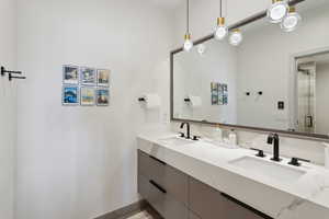 Bathroom with double vanity and baseboards