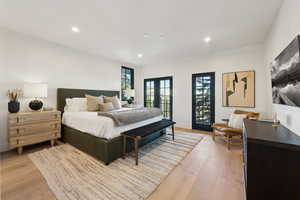 Bedroom featuring french doors, light wood-type flooring, recessed lighting, and baseboards