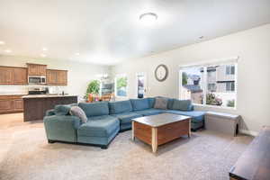 Living room with a chandelier, recessed lighting, and light carpet