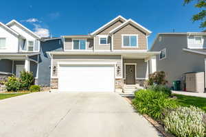 Craftsman house with driveway, a garage, and brick siding