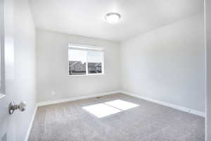 Empty room with carpet flooring and baseboards