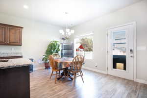 Dining area featuring light wood finished floors, a chandelier, and baseboards