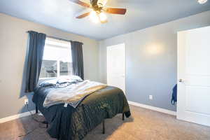 Bedroom featuring carpet, baseboards, and a ceiling fan