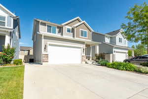 View of front of property featuring an attached garage, concrete driveway, and cooling unit