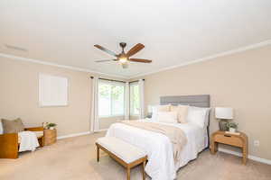 Bedroom with crown molding, light colored carpet, baseboards, and ceiling fan