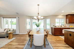 Dining room featuring a chandelier, light wood finished floors, baseboards, and recessed lighting