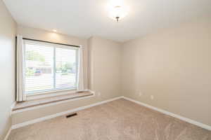 Empty room featuring carpet flooring and baseboards