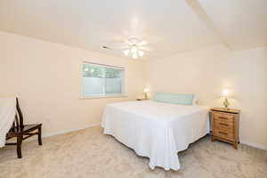 Bedroom featuring light colored carpet, baseboards, and a ceiling fan
