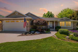 Ranch-style house featuring a porch, concrete driveway, a front yard, a garage, and brick siding