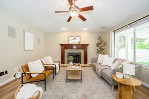 Living area featuring light wood-style flooring, baseboards, healthy amount of natural light, and ceiling fan