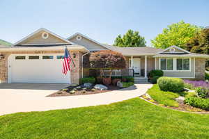 Ranch-style house featuring a garage, a porch, concrete driveway, a front lawn, and brick siding