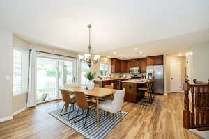Dining area with light wood-style flooring, a chandelier, baseboards, and recessed lighting
