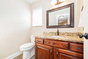 Bathroom with vanity, baseboards, and toilet