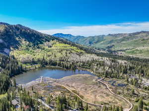 View of property location with a forest and a water and mountain view