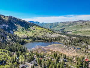 Aerial view of property's location featuring a forest and a water and mountain view