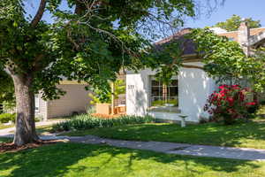 View of front facade featuring a front lawn and stucco siding