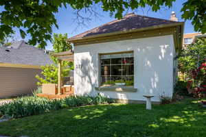 View of property exterior featuring a yard, stucco siding, and a chimney