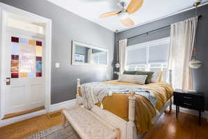 Bedroom with wood finished floors, a ceiling fan, and baseboards