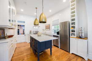 Kitchen featuring appliances with stainless steel finishes, a sink, white cabinetry, and recessed lighting