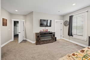 Carpeted living area featuring baseboards and recessed lighting