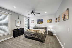 Bedroom featuring recessed lighting, baseboards, carpet flooring, a ceiling fan, and wooden walls