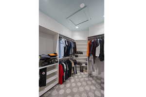 Spacious closet with attic access and carpet flooring