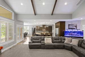 Living room with recessed lighting, baseboards, beam ceiling, and light colored carpet