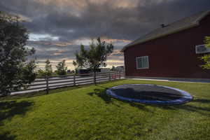 Yard at dusk featuring a trampoline