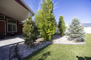 View of green lawn with a patio area