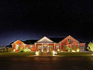View of front of property.. Yard lights on a timer and eave lights on home