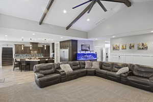 Living area with recessed lighting, ceiling fan, high vaulted ceiling, light carpet, and wood ceiling with exposed beams