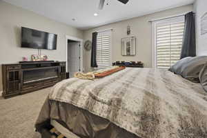 Carpeted bedroom featuring ceiling fan and recessed lighting