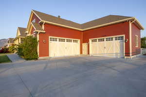 View of home's exterior with driveway, a garage, and a shingled roof