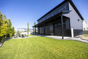 Rear view of pool house with a mountain view, a patio