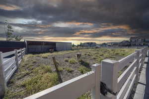 Yard at dusk with an outbuilding and an outdoor structure
