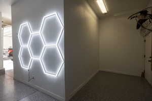 new epoxy floor in  main garage with hexagon lights on walls and ceiling.