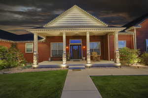 Doorway to property with a porch and a lawn