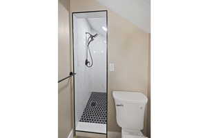 Bathroom featuring a marble finish shower, toilet, and baseboards