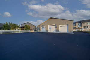 View of property exterior featuring a detached garage and an outdoor structure