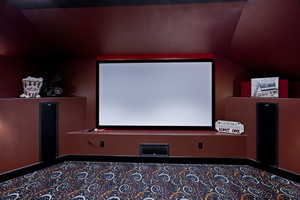 Home theater room featuring vaulted ceiling and 120" projection screen.