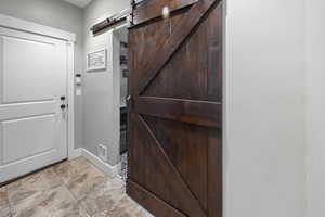Foyer featuring a barn door and baseboards
